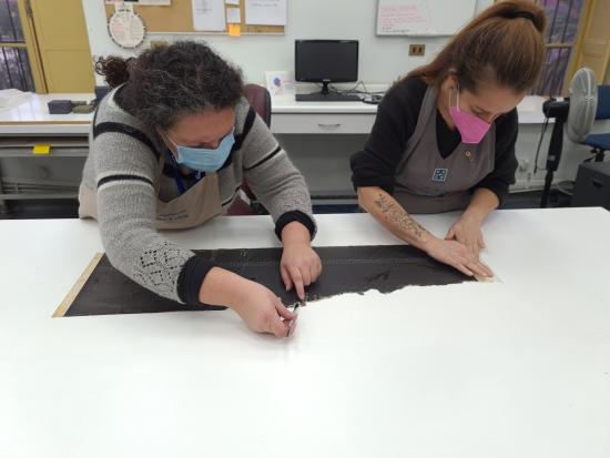 Figura 39. Claudia Pradenas y Vianka Hortuvia durante el proceso de laminado (Fotografía: Pinilla Rodríguez, O. 2021. Archivo CNCR. UPGD901.29). 